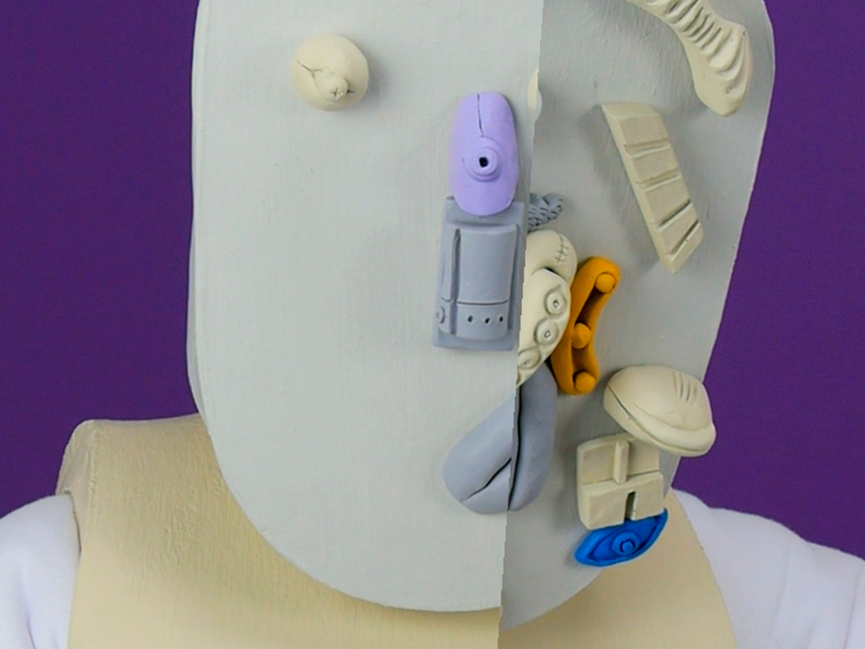 Contemporary sculpture with grey, beige, lavender, blue and orange shapes on the head with a dark purple background